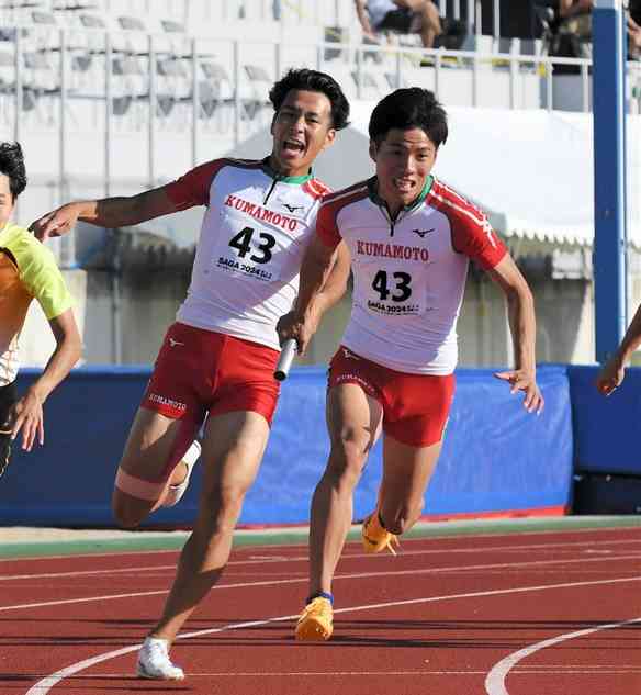 【陸上成年少年男子共通400メートルリレー準決勝1組】熊本の2走齊藤（左）からバトンを受け取る3走春木＝佐賀県SAGAサンライズパーク陸上競技場