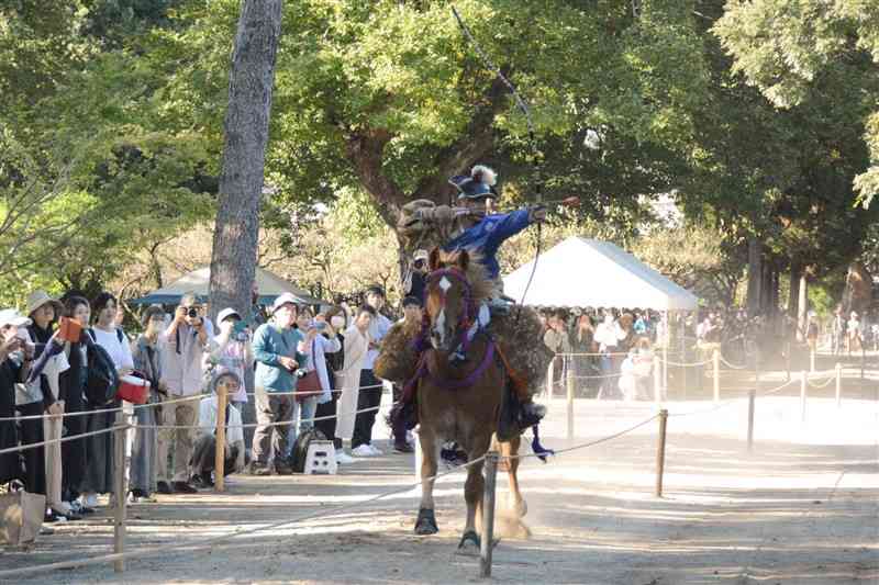 出水神社の秋季例大祭で、馬上から矢を射る射手＝13日、熊本市中央区