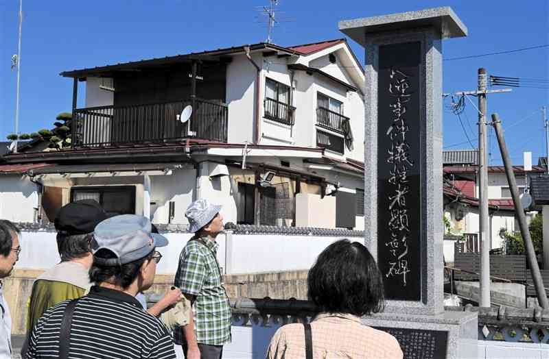 本澄寺に建つ「大逆事件犠牲者顕彰碑」を訪れた熊本近代史研究会のメンバー＝13日、山鹿市