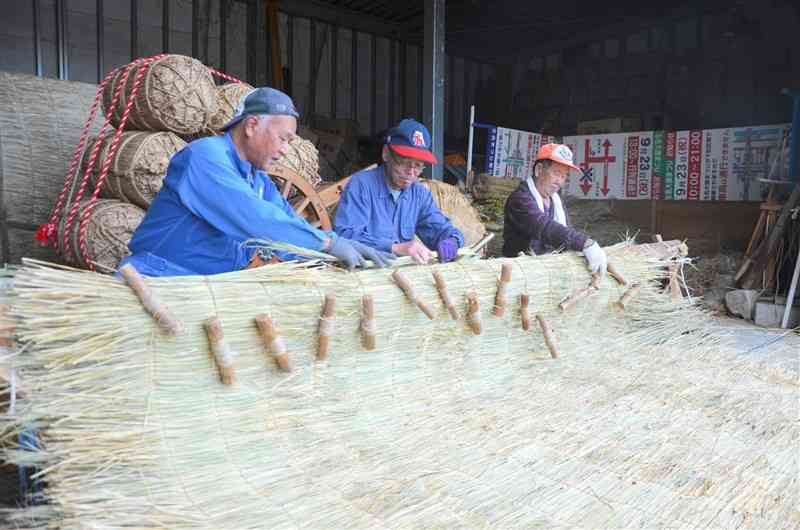 横一列に並んで薦を編むシルバー人材センターの会員＝11日、玉名市