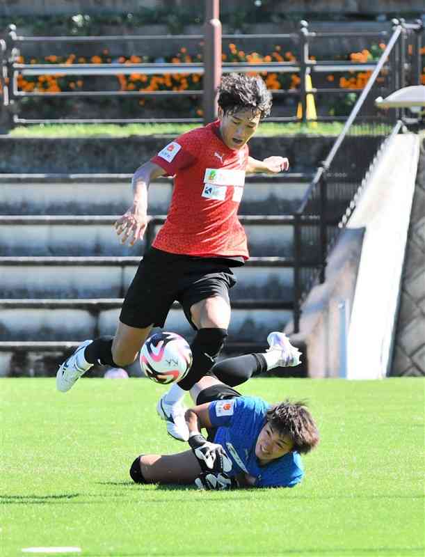 18日の練習で、ロアッソ熊本のGK佐藤史（下）をかわすFW石川＝県民総合運動公園ラグビー場