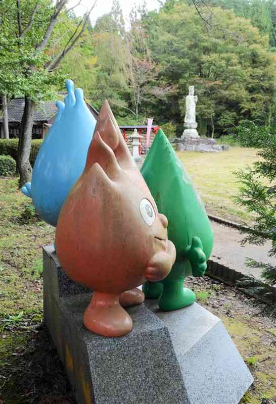 子安河原観音公園の一角に立つ「ひのっこ」。奥は子安河原観音＝15日、阿蘇市