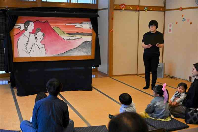 NPO法人「南阿蘇えほんのくに」の誕生祭で、大型紙芝居を披露するスタッフ＝19日、高森町