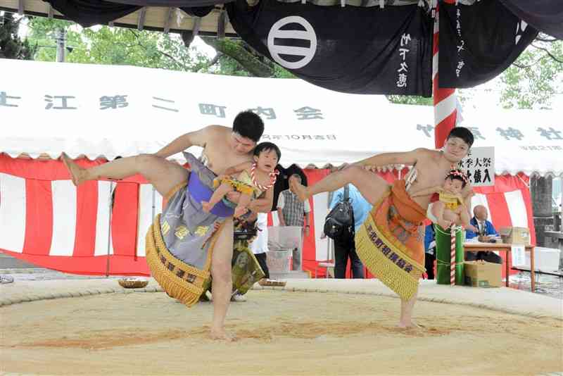 力士に抱えられ、土俵入りする赤ちゃん＝19日、八代市