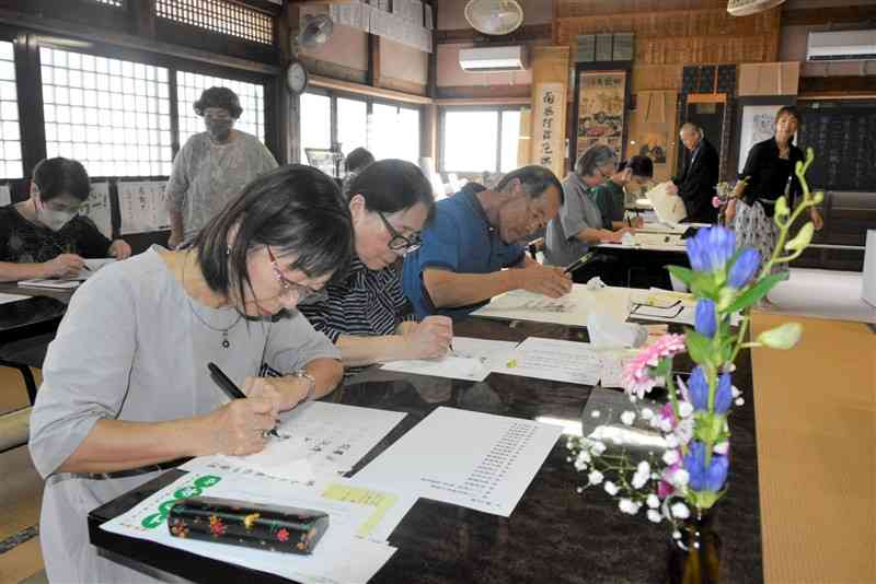 来迎寺のイベント「てらギャラ」で、写経や写仏をする参加者＝19日、芦北町