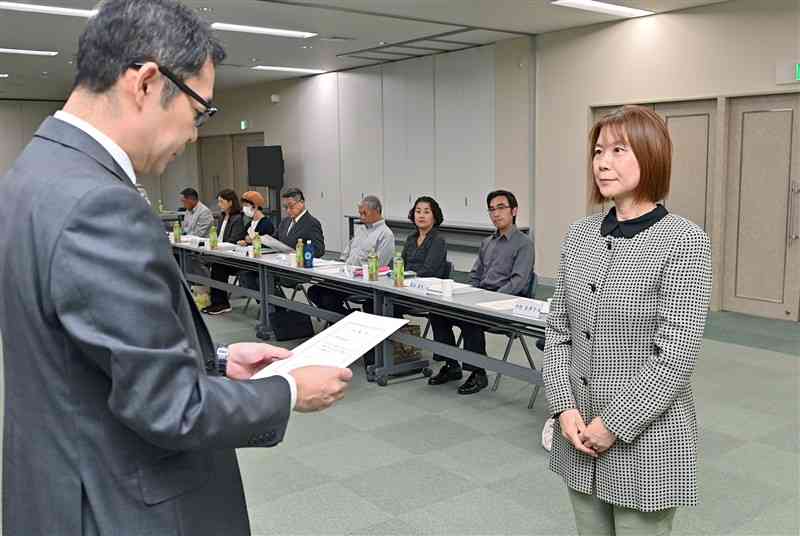 第45期熊日モニター会議で、伊豆信太郎社長（左）から代表で委嘱状を受け取る中村美津子さん＝24日、熊本市中央区の熊日本社（上杉勇太）