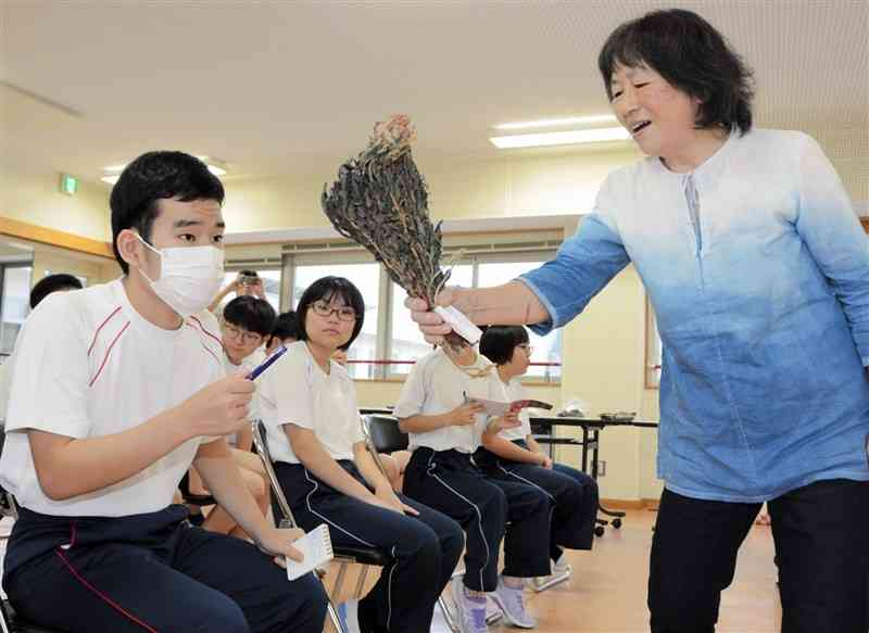 乾燥させた藍について、金刺宏子さん（右）に質問する生徒＝22日、熊本市中央区