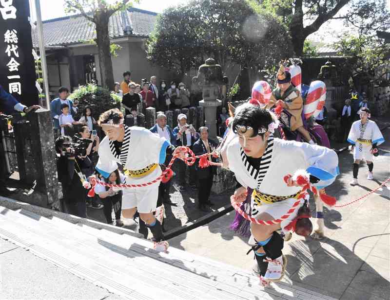 稚児を乗せた飾り馬を引き、参道を駆け上がる男衆＝10月27日、玉名市