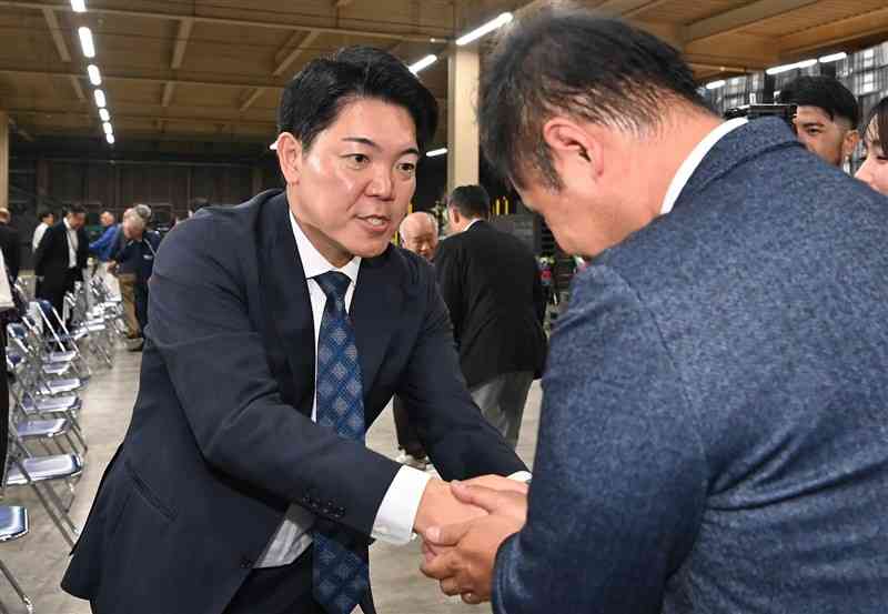 当選確実となり、支持者と握手する西野太亮さん＝27日午後8時30分ごろ、熊本市南区のJA選果場（石本智）