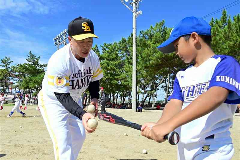 プロ野球ソフトバンクの野球教室で、元選手の田口昌徳さん（左）から打撃を教わる子どもたち＝27日、長洲町