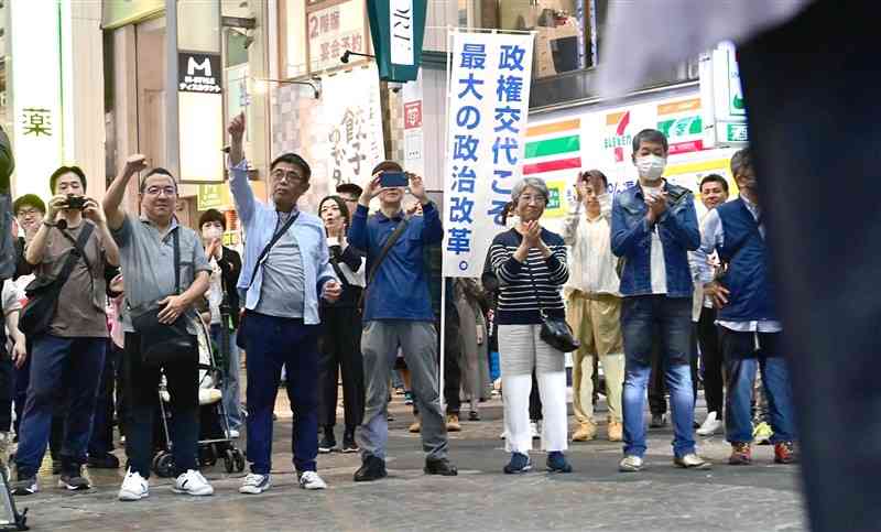 立憲民主党の出口慎太郎氏の演説を聞く支持者ら。政権交代を訴えるのぼりも掲げられた＝26日、熊本市中央区（谷川剛）