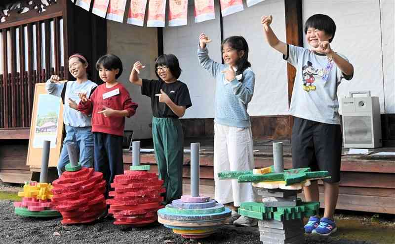 アート感覚あふれる作品の前でポーズを取る子どもたち＝10月27日、小国町