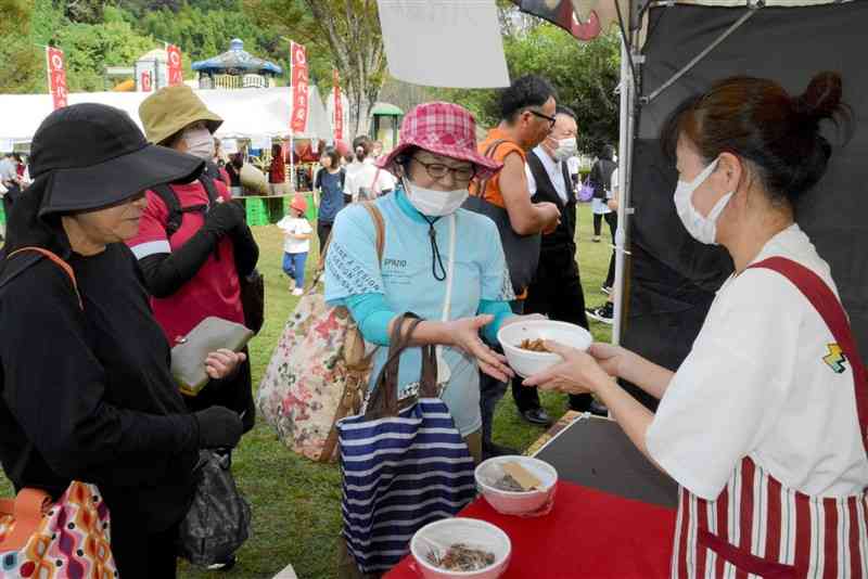 「豚肉の生姜焼きコンテスト」で丼を買い求める客＝10月27日、八代市