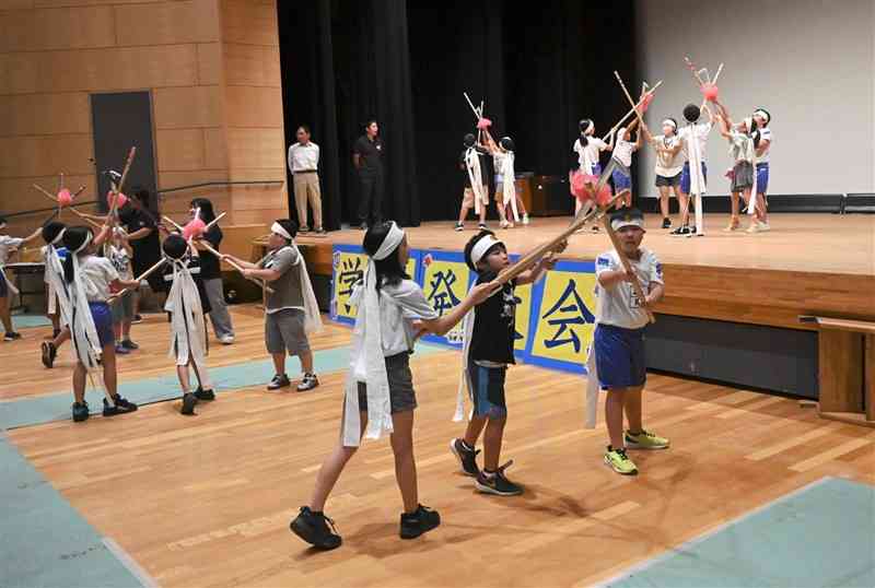 息を合わせて上手石坂棒踊りの練習に励む児童たち＝29日、あさぎり町