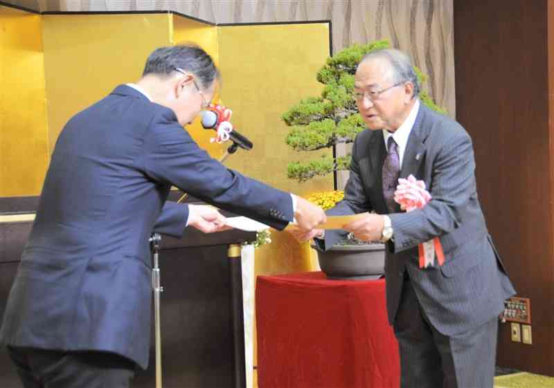 山崎博之・熊本国税局長（左）から表彰状を受け取る被表彰者＝31日、熊本市中央区