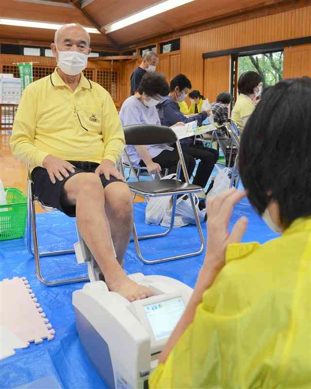 「体を知る日」に参加し、骨密度の測定を受ける男性＝10月23日、熊本市北区