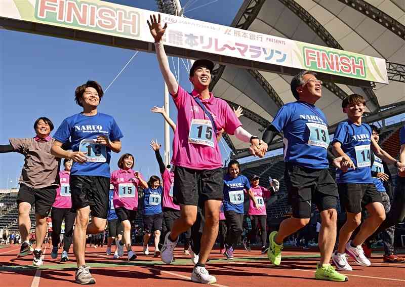 チームメートらと笑顔でフィニッシュする参加者たち＝3日、熊本市東区のえがお健康スタジアム