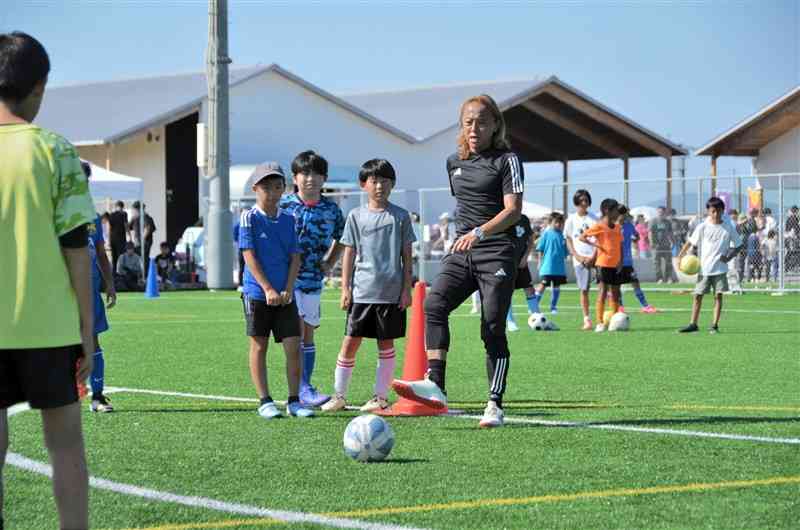 子どもたちにパスの出し方を指導する元日本代表MFの北沢豪さん＝4日、嘉島町