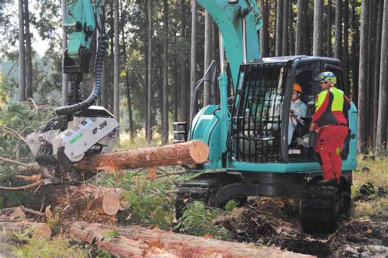 指導を受けながら機械を操作する阿蘇中央高の生徒＝6日、阿蘇市