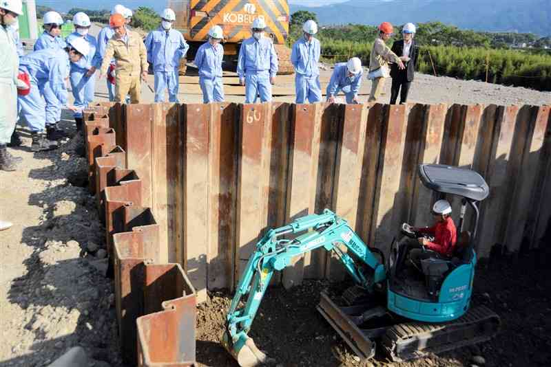 橋台部分の掘削作業を見学する南稜高の生徒たち＝6日、錦町