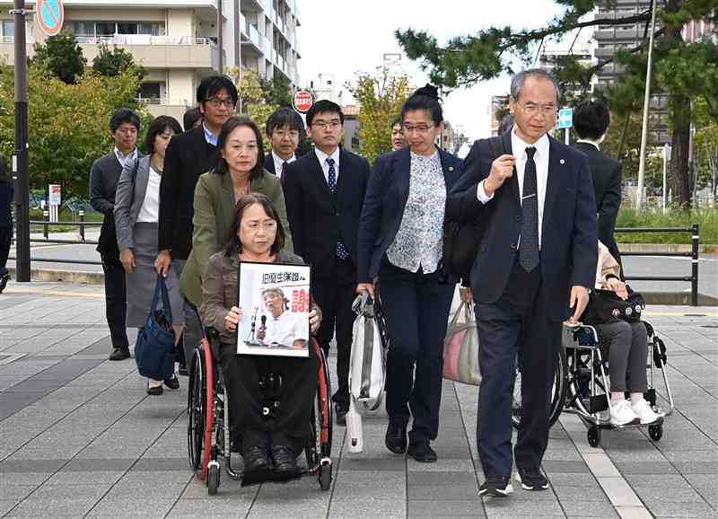 渡辺数美さんの遺影とともに福岡高裁に入る旧優生保護法をめぐる熊本訴訟の原告ら＝7日午後2時35分ごろ、福岡市中央区（石本智）