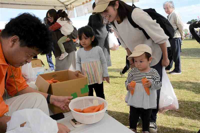 ニンジンの重さ当てに挑戦する子どもたち＝9日、菊陽町