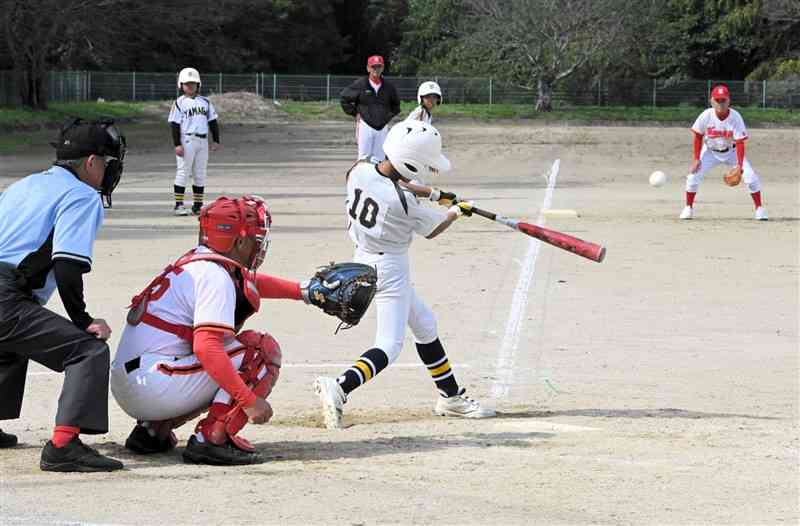 熱戦を繰り広げた還暦チームと山鹿少年野球クラブ＝9日、山鹿市