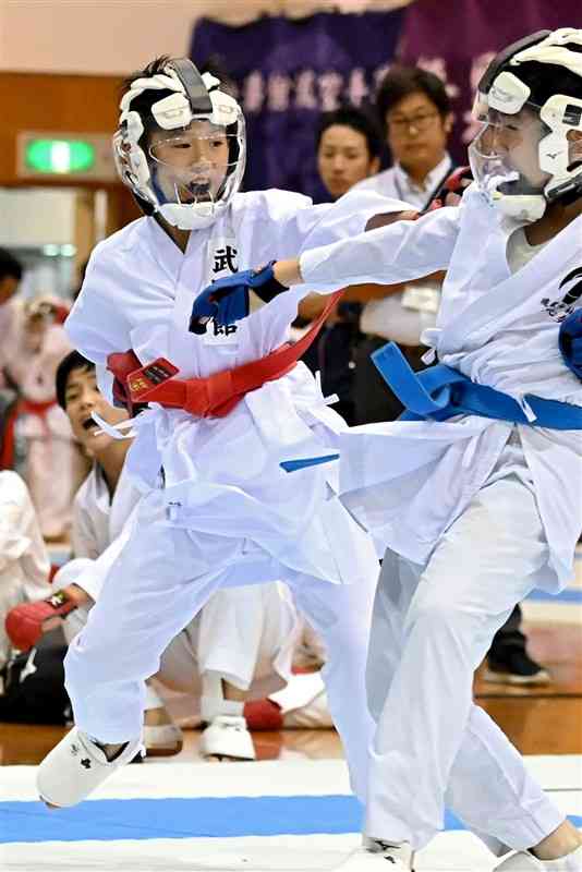 【団体組手5・6年男子決勝・武隆館－月心会熊本県本部】中堅戦。突きで攻める武隆館の大村（左）＝菊池市総合体育館（石本智）