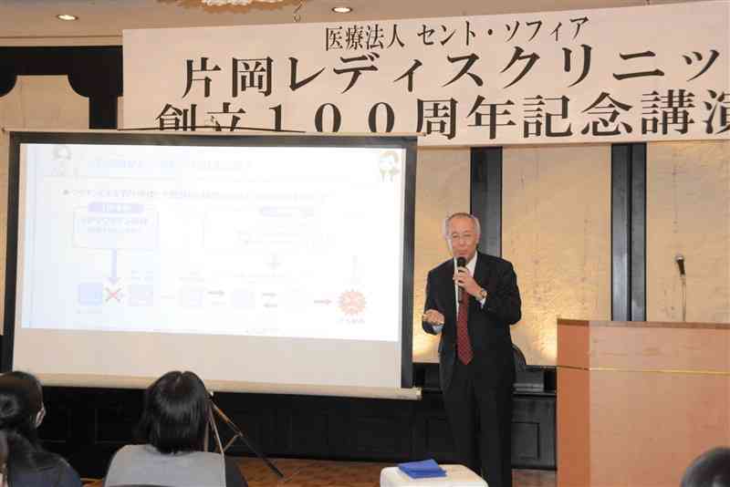 創立100周年記念講演会で子宮がんについて説明する片岡明生理事長＝16日、八代市