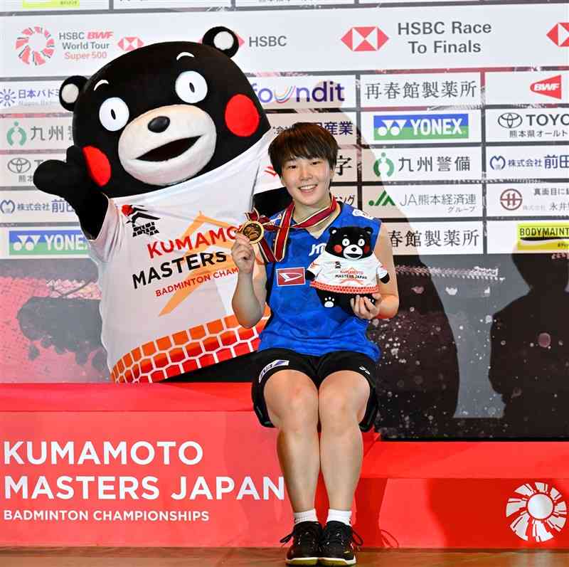 バトミントン熊本マスターズジャパン2024の女子シングルスで初優勝を飾り、くまモンと記念写真に納まる山口茜（再春館製薬所）＝17日午後、熊本市の熊本県立総合体育館（石本智）