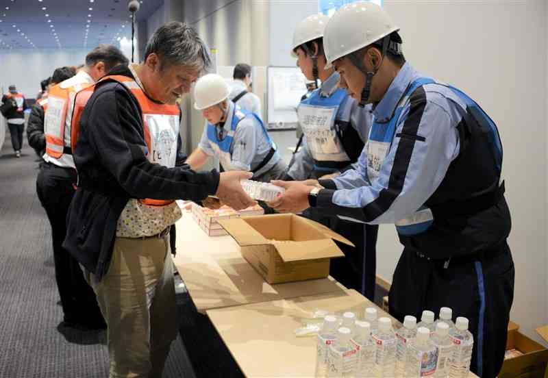 帰宅困難者の受け入れ訓練で、食料や水を配る熊本城ホールなどの施設職員ら＝18日、熊本市中央区