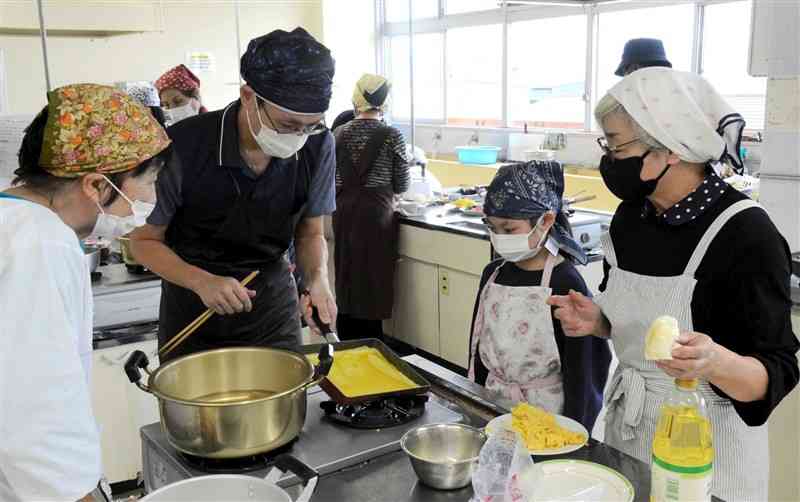 ちらしずし用の錦糸卵を作る台湾の会員（左から2人目）＝15日、菊陽町