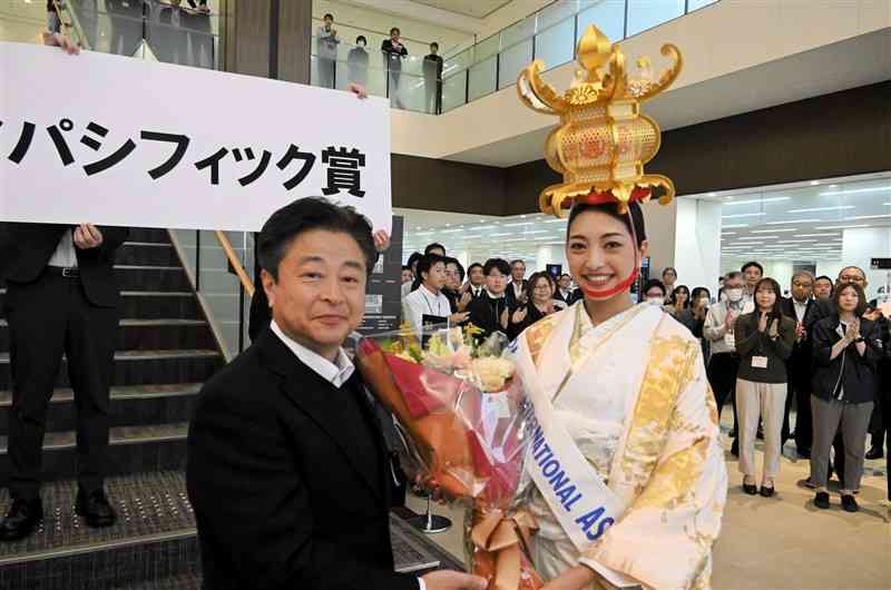 山鹿市役所を訪れた植田明依さん（右）に花束を贈る早田順一市長＝20日