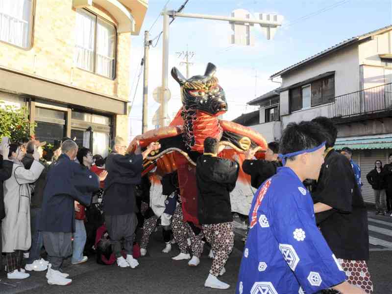 八代妙見祭の神幸行列で、見物客に近づく亀蛇＝23日、八代市