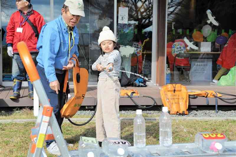 ジェットシューターで放水の体験をする子ども＝23日、阿蘇市