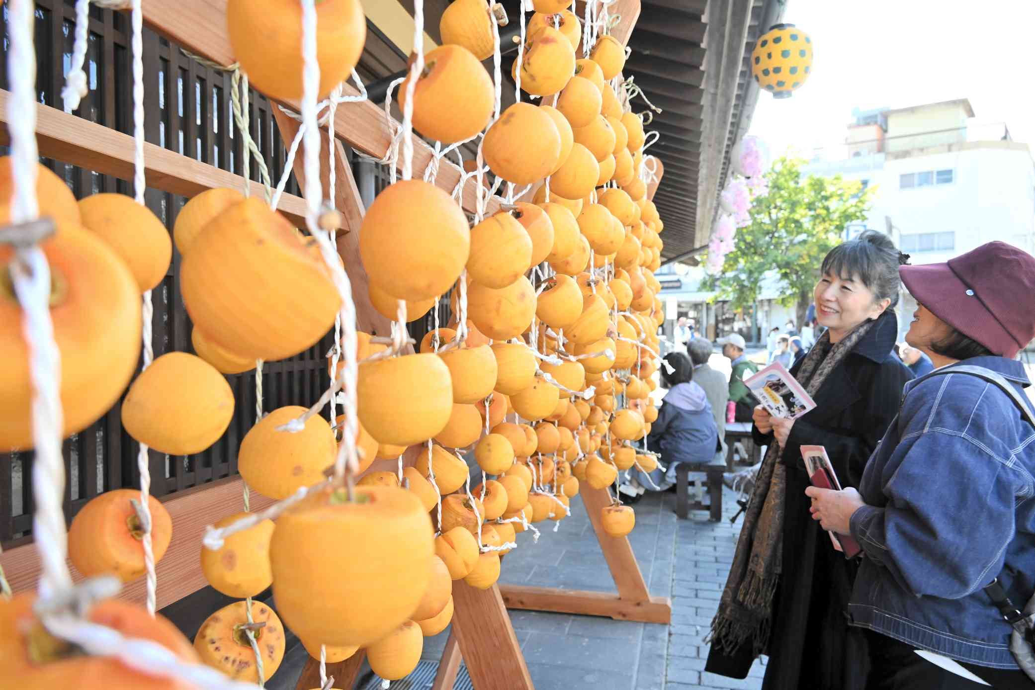 さくら湯の軒下につるされた渋柿＝23日、山鹿市