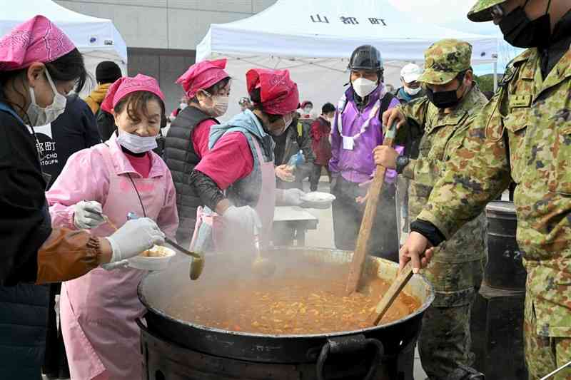 防災訓練で、自衛隊員と共同で炊き出しをする住民ら＝24日、山都町