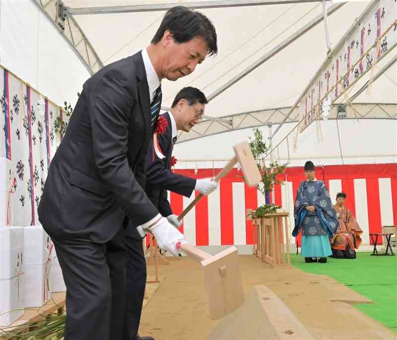 神事でくわを振る大牟田・荒尾清掃施設組合管理者の関好孝大牟田市長（奥）と副管理者の浅田敏彦荒尾市長＝26日、大牟田市