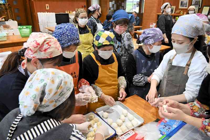 くまもとふるさと食の名人の富田美代子さん（左から3人目）からクリ団子の作り方を教わる参加者＝26日、山鹿市