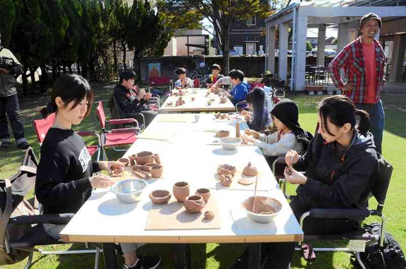 楽焼のワークショップで粘土を思い思いの形に成型する参加者＝11月23日、天草市