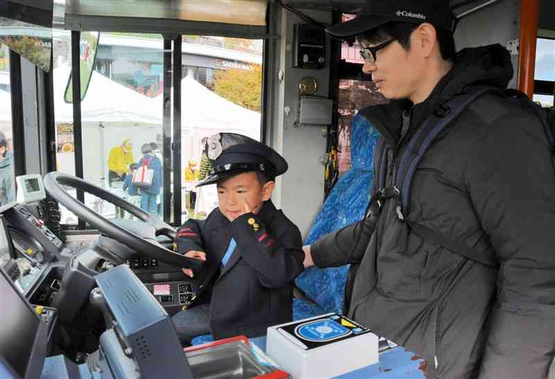 「バス・電車〝元気〟フェスタ」で、運転手の制服を着て体験乗車する子ども＝30日、熊本市中央区