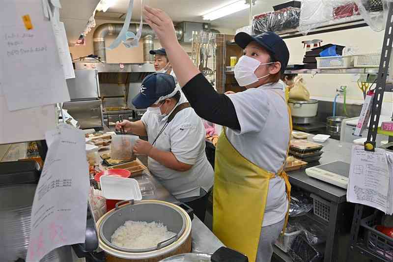 アルバイト先の弁当店で、注文の弁当を準備する3年の川﨑沙智さん（右）＝10月29日、熊本市東区の「本家かまどや尾ノ上3丁目店」（上杉勇太）