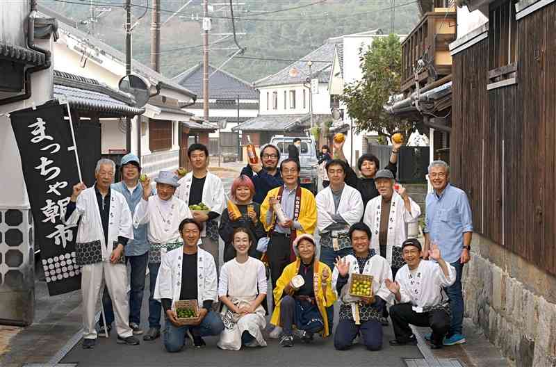 土蔵白壁造りの家々が並ぶ松合地区で、毎月第3日曜日に「まっちゃ朝市」を開催している「まっちゃ活かそう会」のメンバーら＝宇城市（小野宏明）