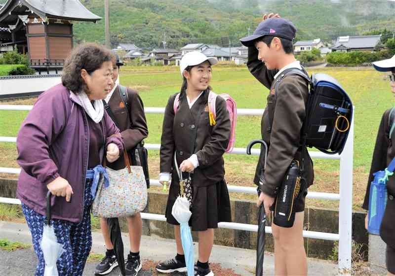 道に迷っている認知症役の女性に対し、優しく声をかける栖本小の児童＝11月26日、天草市