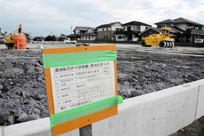 農地を転用して造成が進む八代市千丁支所の隣にある住宅用地。後方にも住宅街が広がる＝11月21日、八代市