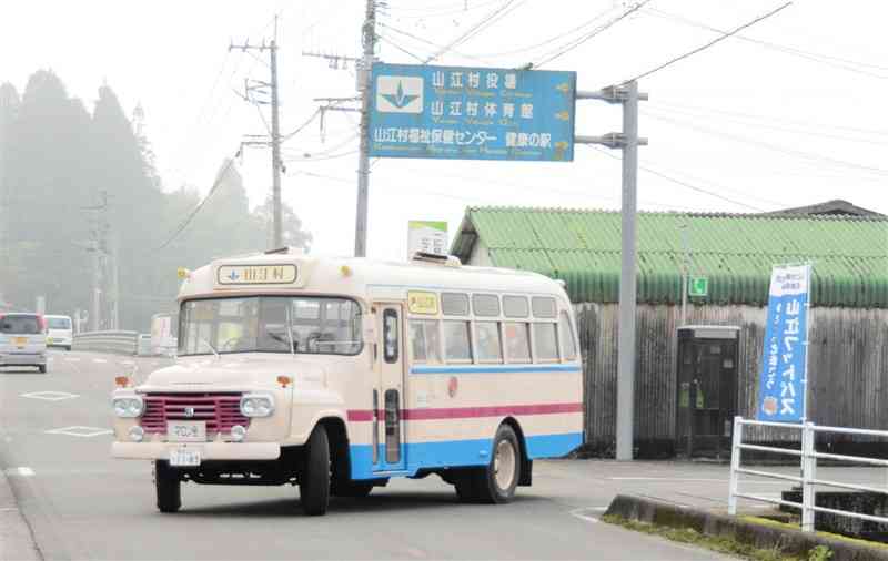 フットパスイベントの参加者を乗せて村役場を出発する「マロン号」＝11月23日、山江村