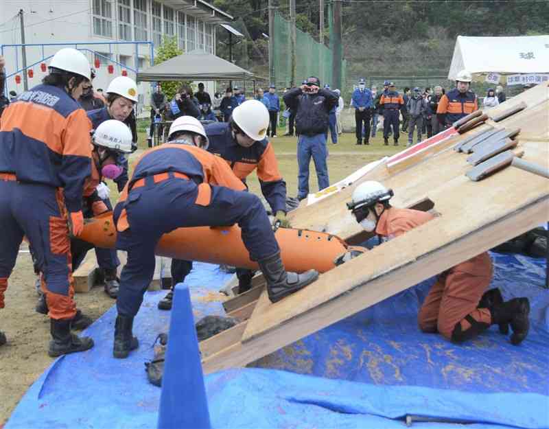 倒壊家屋の模型を使い、けが人の救出訓練をする消防団員ら＝1日、球磨村