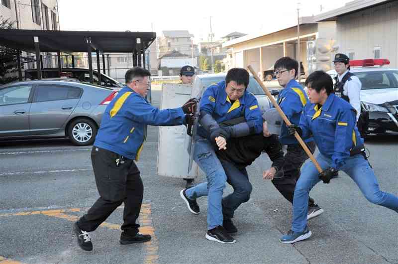 広域緊急配備訓練で、刃物を持った男を取り押さえる熊本県警の警察官たち＝3日、玉名市