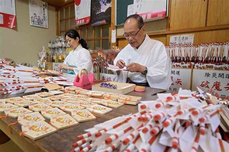 縁起物の破魔矢を作る四山神社の黒田明司宮司（右）ら＝6日、荒尾市