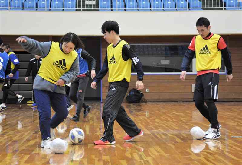 新聞紙で作ったボールを活用したサッカーの授業を体験する小学校教員ら＝7日、熊本市西区